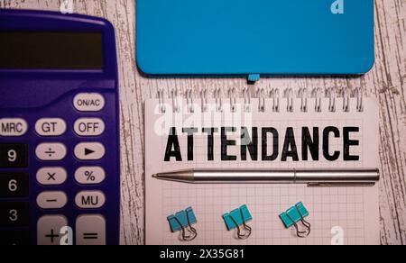 Word ATTENDANCE written on a book with gift boxes against wooden table Stock Photo