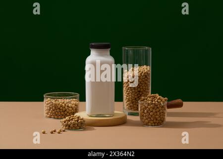 Soy milk bottle is placed on a wooden podium. Glass containers containing a lot of soybeans. Soy extract is a great source of vitamins, minerals, and Stock Photo