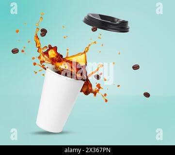 Aromatic coffee splashing in takeaway paper cup and flying roasted beans on turquoise background Stock Photo