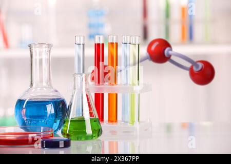 Different glassware and molecule model in laboratory Stock Photo