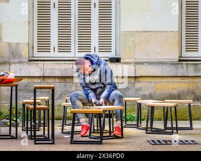 Man without protective face-mask using power tool sanding wood tops of stools - Tours, Indre-et-Loire (37), France. Stock Photo