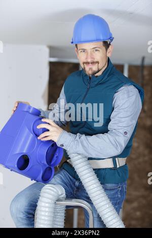 young male technician repairing air conditioner indoors Stock Photo