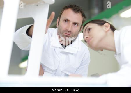 painter teaching paintbrush technique to apprentice Stock Photo