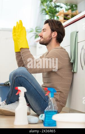frustrated man cleaning up water leaked from washing machine Stock