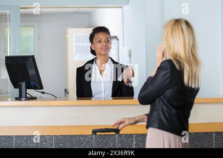 hotel reception worker with female customer Stock Photo