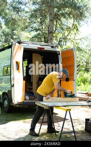 Man working with wood to camper a van Stock Photo