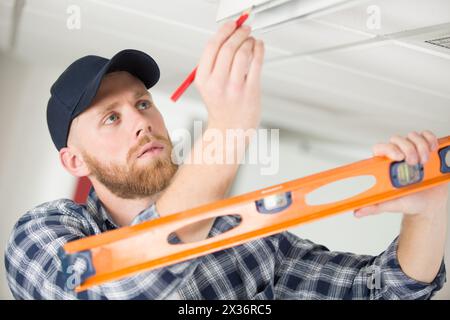 taking ceiling measures with spirit level Stock Photo