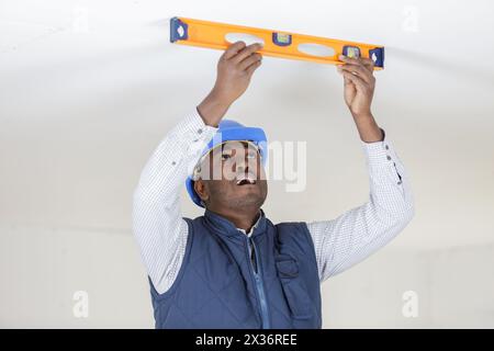 taking measures with spirit level before drilling the ceiling Stock Photo