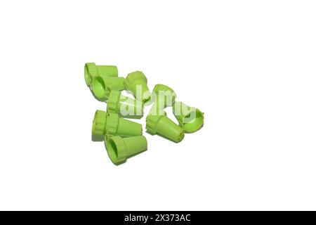 On a white background there are various shapes of nozzles for a pastry syringe, green nozzles. Stock Photo