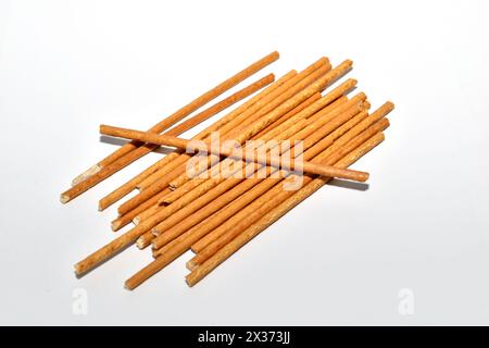 Confectionery sticks called sweet straws, made from durum wheat flour, lie on a white background. Stock Photo