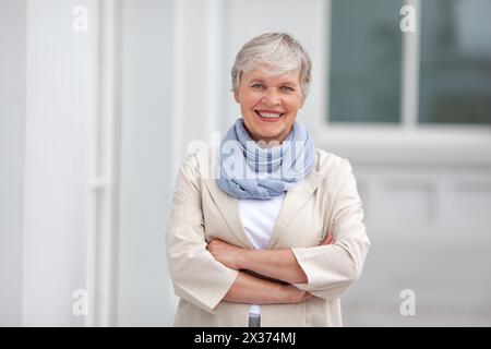 Mature happy beautiful smiling professional business woman, happy confident positive model entrepreneur standing outdoor on street arms crossed, femal Stock Photo