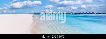 Luxury resort with water villas and close to blue sea waves, seascape. Summer vacation holiday, beach on tropical island coast, shore. Paradise travel Stock Photo