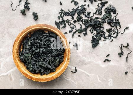 Dried wakame seaweed in bowl on a kitchen table. Top view. Stock Photo