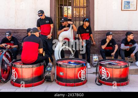 Musicians Rest In The Shade Before Performing In La Fiesta de la Virgen de la Candelaria, San Pedro de Atacama, Antofagasta Region, Chile. Stock Photo