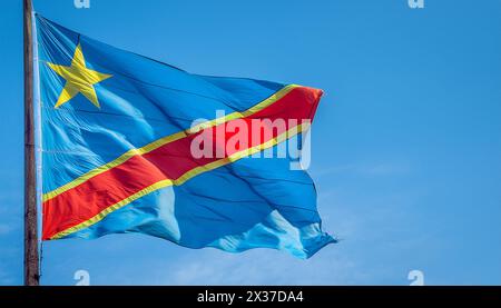 Die Fahne von Demokratische Republik Kongo flattert im Wind, isoliert gegen blauer Himmel Stock Photo