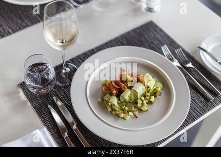 Delicious shrimp dish served with fresh vegetables on white plate. Elegant  shrimp appetizer cucumber rounds, garnished with fresh dill sprigs. Stock Photo