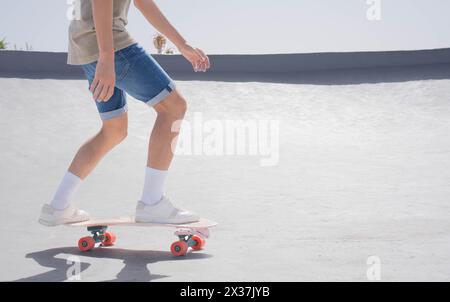 A young man is skillfully skateboarding on a ramp with a surfskate, showing off tricks and maneuvers in a skate park setting. Stock Photo