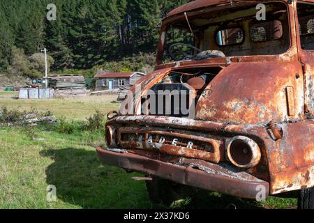 Rusty Thames Trader truck and old houses at Endeans Mill, near Taumaranui, North Island, New Zealand Stock Photo