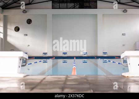 Swimmers are not visible, only an empty indoor pool awaits indoors, copy space Stock Photo