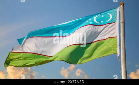 Fahnen, die Nationalfahne von Usbekistan  flattert im Wind Stock Photo