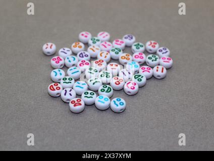 Decorative plastic beads with funny faces. White decorative stones for the necklace. Stock Photo