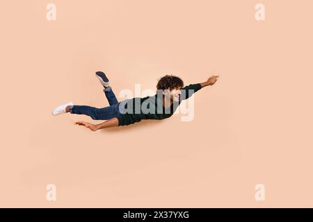 Full body portrait of nice young man fly empty space wear sweater isolated on beige color background Stock Photo