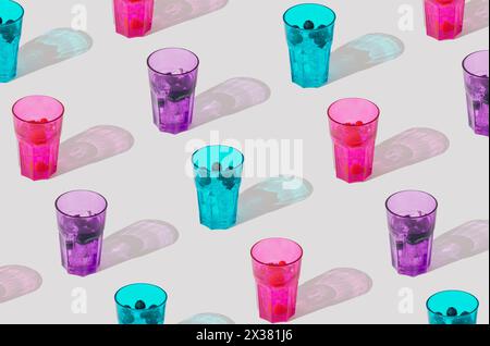 Summer sunlight pattern of colorful glasses with raspberry, blueberry and blackberry tropical refreshing drinks on white background. Minimal concept. Stock Photo