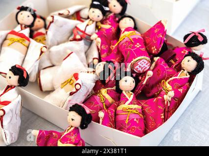 Small Japanese dolls in kimono in a box. Japanese souvenirs. Stock Photo