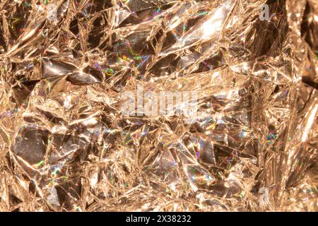 A Holographic Crumpled Gold Bronze Paper Material which is Shiny for Background Stock Photo