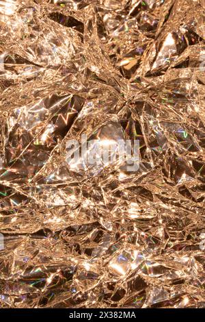 A Holographic Crumpled Gold Bronze Paper Material which is Shiny for Background Stock Photo