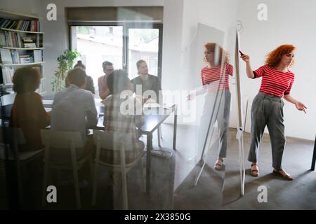 Young businesswoman leading a discussion during a meeting with her colleagues. Stock Photo