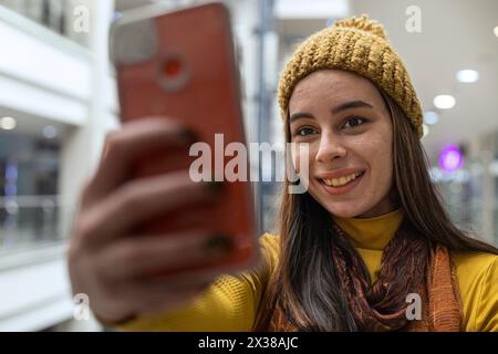 Young Latin American woman smiling and taking a selfie Stock Photo