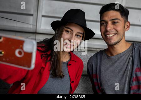 Two young Latin American brothers happily share some time together taking a family self-portrait. Technology concept. Stock Photo