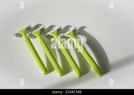 Green disposable shaving razors on white background Stock Photo