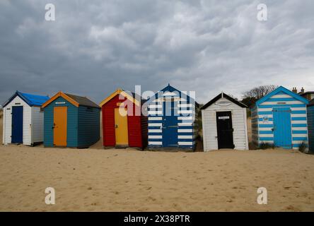 Southwold, Suffolk, UK. 25th April 2024. UK weather: mixture of sunshine and showers at Southwold, Suffolk. Old beach huts named after famous people and monarchs by sand dunes at Southwold Denes beach, Credit: Carolyn Jenkins /Alamy Live News Stock Photo