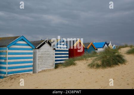 Southwold, Suffolk, UK. 25th April 2024. UK weather: mixture of sunshine and showers at Southwold, Suffolk. Old beach huts named after famous people and monarchs by sand dunes at Southwold Denes beach. Credit: Carolyn Jenkins /Alamy Live News Stock Photo