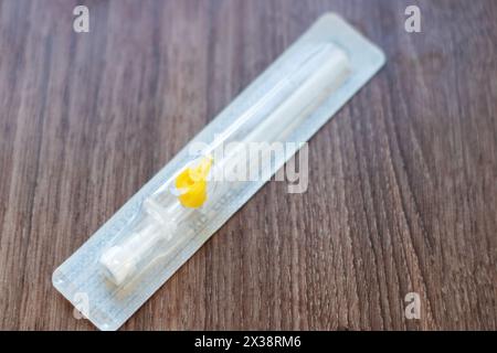 A kitchen utensil made of white hardwood, with a yellow tip, is placed on a rectangular table. The tool can be used for ingredient preparation in cuis Stock Photo