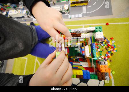 MOSCOW - DEC 5, 2016: Hands of boy playing with erector set Lego, The company Lego Group was founded in 1932 Stock Photo