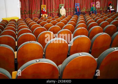 MOSCOW - OCT 19, 2016: Rows of seats in empty theater and puppets on chairs on stage with closed curtain in Modern theater Stock Photo