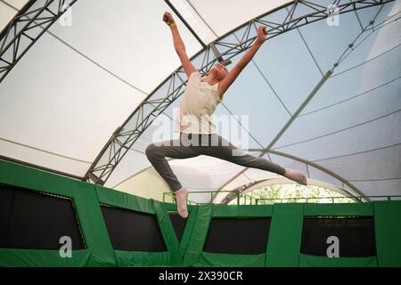 MOSCOW, RUSSIA - AUG 29, 2016: Happy girl (with model release) jumps on trampoline in center Just Jump in Sokolniki park. Trampoline Arena is suitable Stock Photo