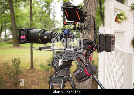 RUSSIA, MOSCOW – 30 JUL, 2015: Professional digital video camera with a wire on a tripod in the Sokolniki park. Stock Photo