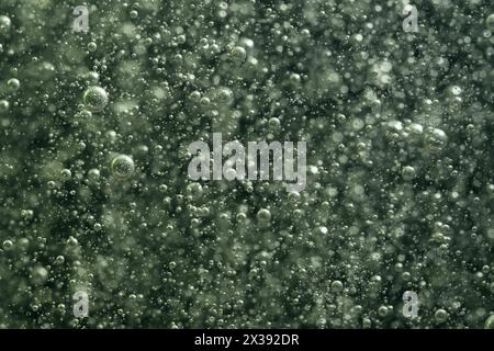Bubbles of air in water on a dark green background Stock Photo
