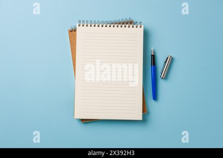 Top view of notebook and fountain pen on blue background Stock Photo