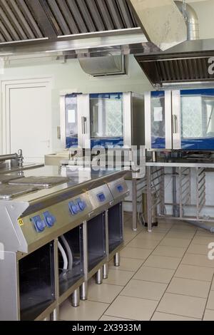 Kitchen room with stoves, heat ovens and refrigerators in restaurant. Stock Photo