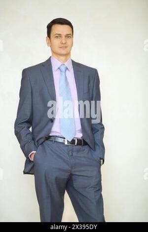 Handsome brunet man in business suit with tie poses in studio Stock Photo