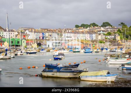 Harbour overlooked by rows of colourful terraced houses under storm sky in summer Stock Photo