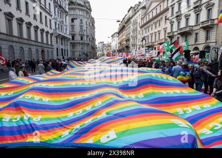 Milan, Italy. April 25, 2024, A peace flag is displayed during the demonstration to mark the 81st anniversary of the Liberation Day, on April 25, 2024 in Milan, Italy. On April 25th, 1945, Italian partisans launched a massive uprising against the fascist regime and Nazi occupation, marking the date as Liberation Day, which honors the critical turning point when Italy began its liberation from fascist and Nazi control. Stock Photo