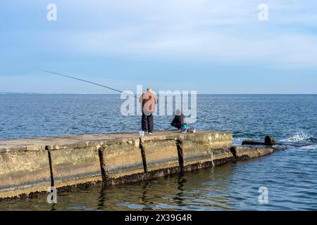Fishermen on the pier catch fish Stock Photo