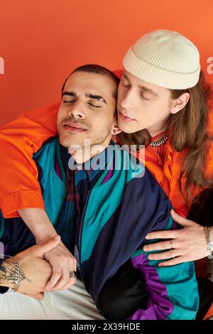 A loving gay couple, two men, sit closely together. Stock Photo