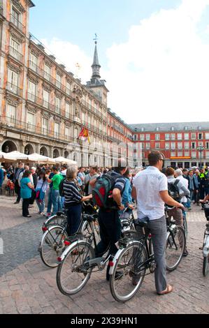 Group of tourists riding bicycles at Plaza Mayor. Madrid, Spain. Stock Photo